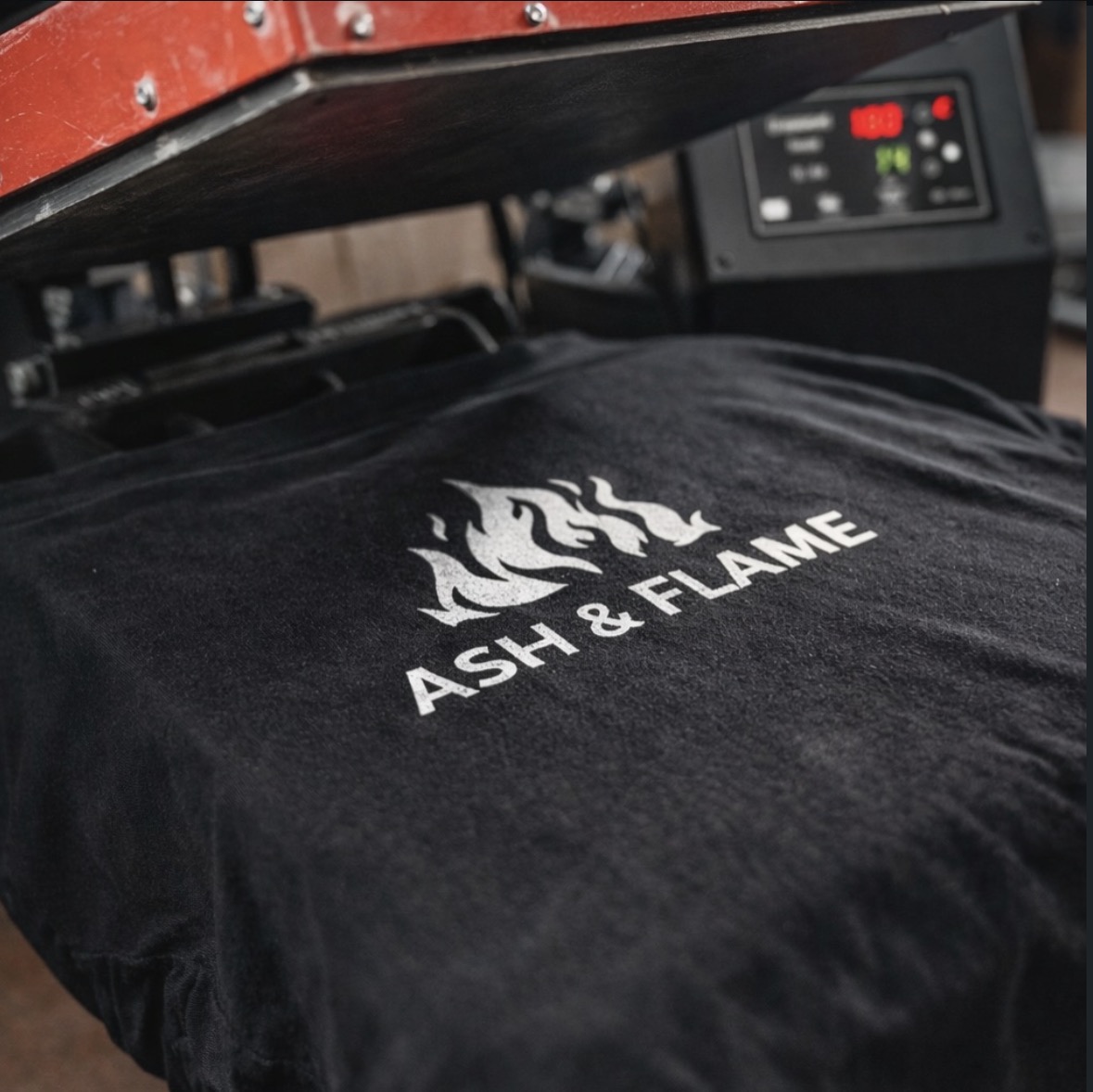 Siebdruckpresse druckt ein schwarzes T-Shirt